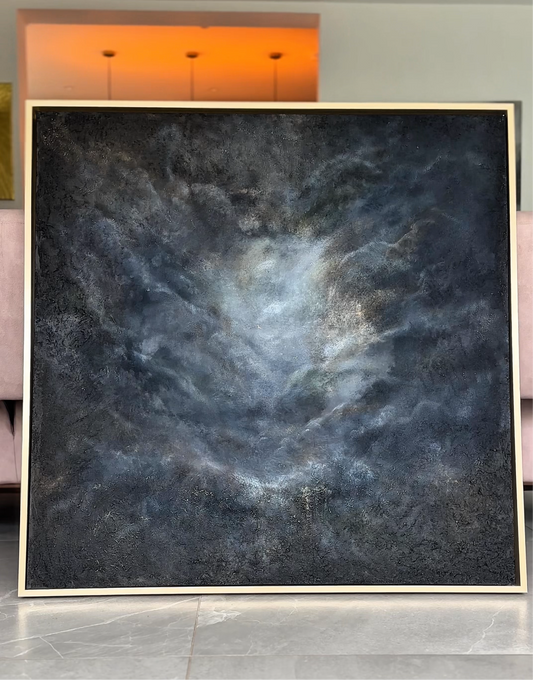 Framed abstract art piece on a wall with a modern interior setting.